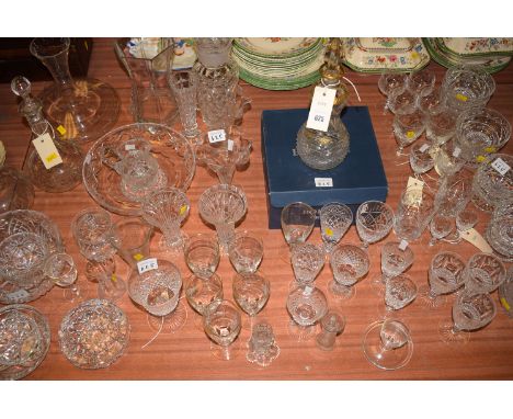 A large collection of cut glass drinking glasses; sundae dishes; an ornate cut glass decanter with gilt decoration; two other