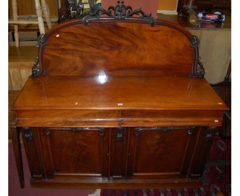 A mid-Victorian mahogany and flame mahogany ledge back sideboard, having twin cushion frieze drawers over conforming lower pa