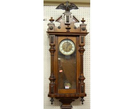 An early 20th century Vienna drop trunk wall clock, with pendulum and eagle surmount, height 90cm
