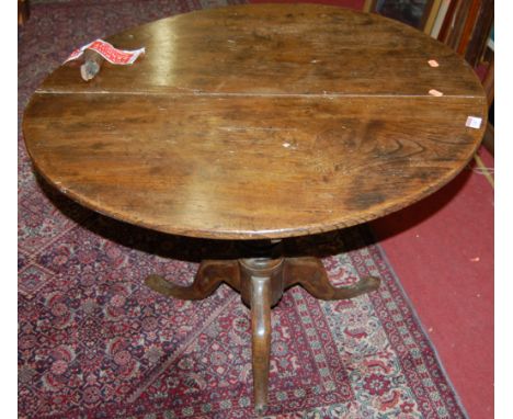 An early 19th century provincial elm and fruit wood circular tilt-top pedestal tripod table (one support damaged), dia. 79cm