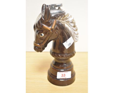A 20th Century treacle glazed table top lighter in the form of a horse's head or chess piece, measuring 19cm tall