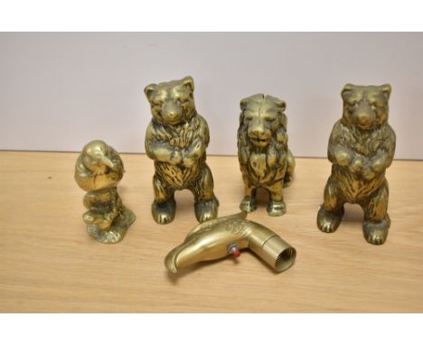 Three brass money boxes, two in the form of bears the other as a lion, as well as a bird paperweight and novelty stick top in