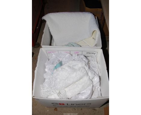 A box of net curtains, along with bath mats, hand and tea towels.