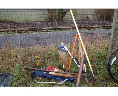 A quantity of tools  to include a lopper, a pick axe, saws, edging shears, etc.