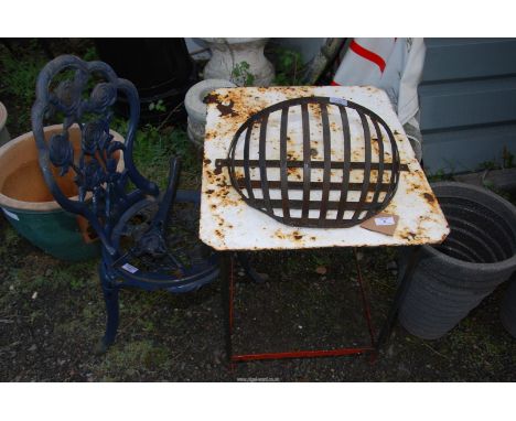A metal table, a cast iron chair (one leg broken) and wall fixing planter basket.