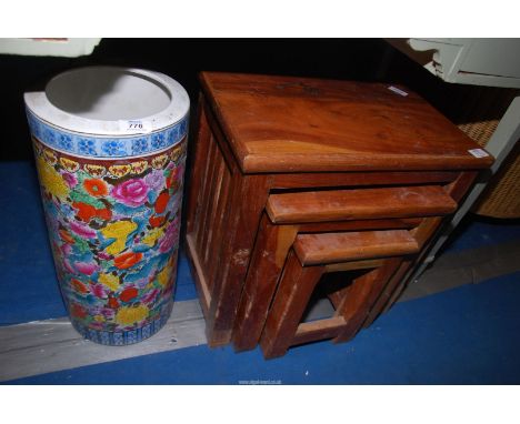 A nest of three tables and a china umbrella/stick pot.