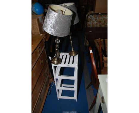 A small white shelf unit and two lamps.