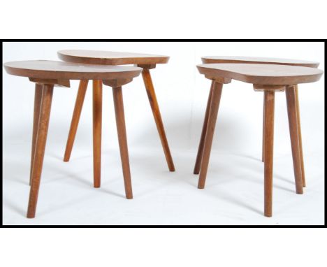 A set of four beech kidney shaped mid 20th century occasional side tables / coffee tables raised on tapering tripod legs. Mea