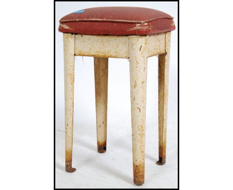 A vintage mid 20th century industrial stool&nbsp;raised on a shaped metal frame with a red vinyl seat pad. Measures 60cm high