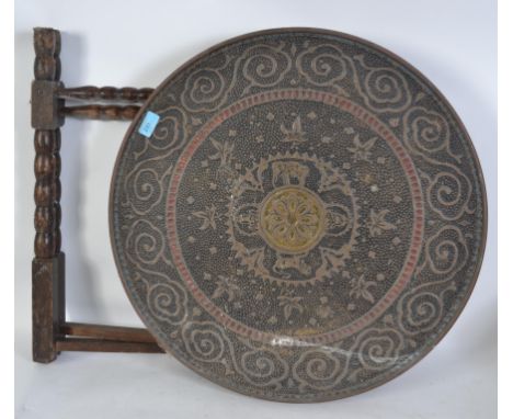 An Anglo Indian brass and enamel &nbsp;tray topped occasional table, the circular brass tray top with stamped decoration, on 