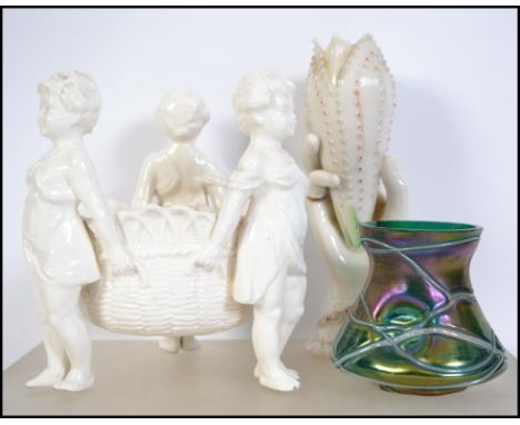 A 20th century ceramic glazed Parian ware type centrepiece rio of cherubs / putti's together with a bud vase in the form of a