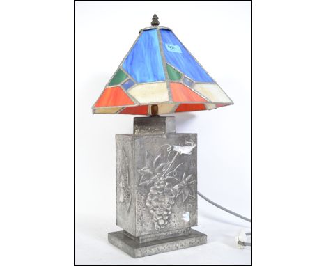 A retro 20th century Tiffany style lamp, having a leaded stained glass shade raised over a silvered metal lamp with grape and
