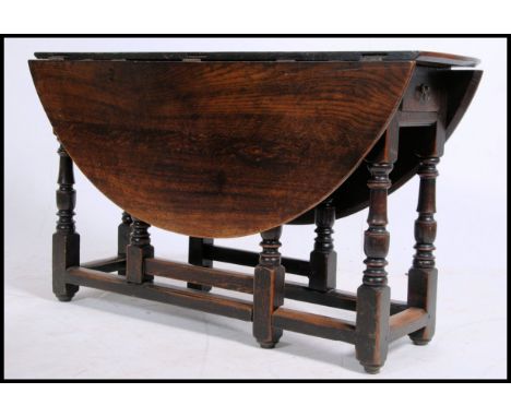 A 19th century country oak gate leg drop leaf dining table raised on turned legs with squared stretchers. The fitted frieze w