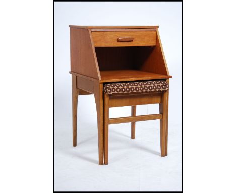 A 1970's retro teak wood Mr Chippy telephone table and chair combination being raised on tapered legs with single drawer and 