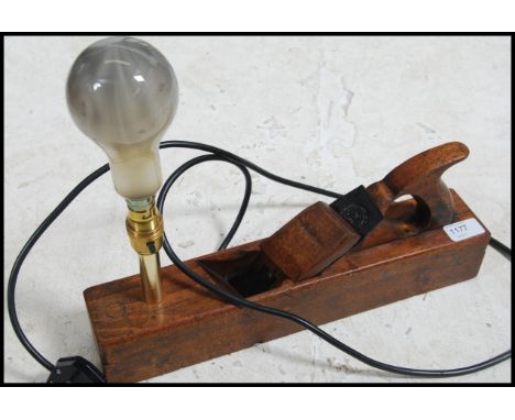 An early 20th century Industrial wood working box plane having a later conversion into a table lamp / light.