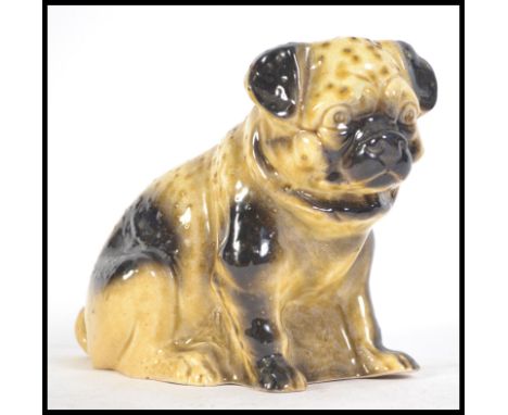 A ceramic 19th century Victorian Staffordshire figurine of a Pug dog. &nbsp;Treacle glazed, of large form with some texture t