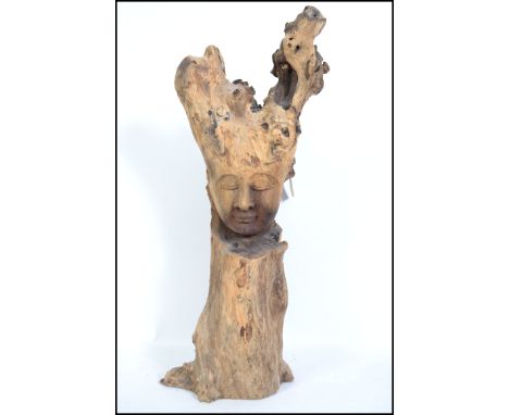 A large vintage 20th century driftwood sculpture with a finely hand carved face to front, thought to be a Buddhist deity. Mea