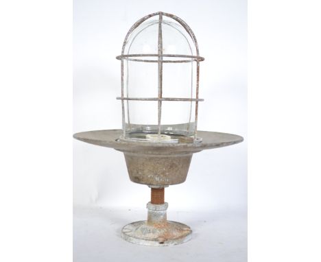A vintage mid 20th century Industrial bulk head light in the manner of The Lighting Fitting Co. Complete with cage.
