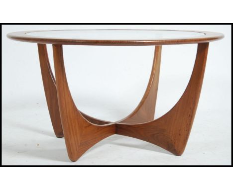 A vintage mid 20th century G Plan atomic teak wood round coffee table with drop in glass centre raised on atomic teak legs. M