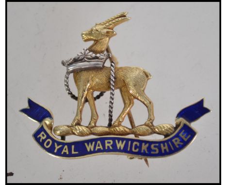 A rare Royal Warwickshire 14ct gold and enamel badge dating to the mid century having roll clasp pin to verso. Total weight 5