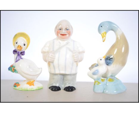 A collection of three vintage ceramic figurines to include a Wade ' Butcher ' along with a Beatrix potter duck in hat and a d