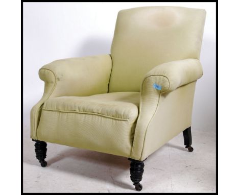A Victorian mahogany Howard &amp; Sons style armchair being raised on turned legs with ceramic castors having overstuffed sea