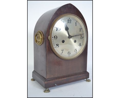 An Edwardian mahogany lancet shaped mantel clock with an eight day movement and silvered dial with roman numeral chapter ring