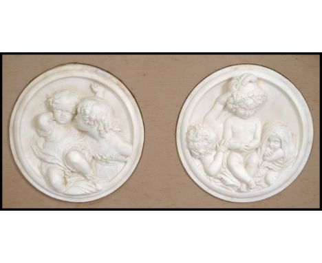 A pair of believed 19th century ceramic Parian ware plaques being cast in relief with classical scenes and set within a good 