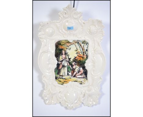 A large wall hanging ceramic wall charger. Italian in origin having a rococo stylized border with a central classical scene p