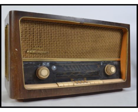 A vintage mid 20th century wooden cased Grundig valve radio. Model 3028 / GB AM / FM receiver.