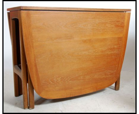 A 1970's 20th century rare Nathan teak wood drop leaf dining table. The full length drop leaves being raised on gate leg acti