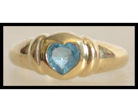 A hallmarked 9ct gold ring set with a heart shaped blue topaz. Hallmarked for Birmingham. Size R. Weight 3.3g.