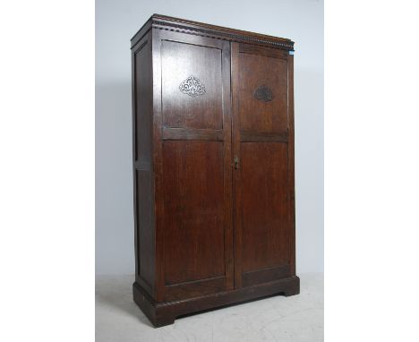 A 1930's oak double wardrobe compactum having oak full length qtr panel doors with haberdashery lined shelves set within. Fla