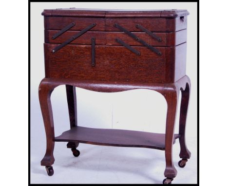 A good mid century oak sewing box with articulated action having ebonised bracket work. All raised on shaped supports with ha