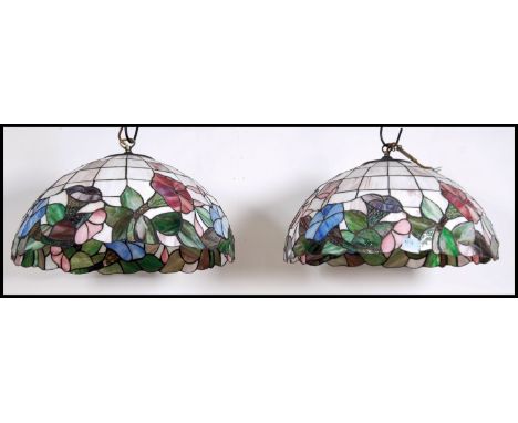 A pair of vintage 20th century Tiffany style leaded glass hanging ceiling light shades with sectioned floral design. Measures