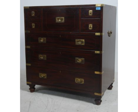 A 20th century antique style mahogany and brass bound cocktail cabinet in the form of a campaign chest. The chest raised on t