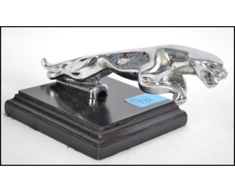 A vintage 20th century chrome plated Jaguar car mascot raised over an ebonised plinth base. Measures 19cm long.