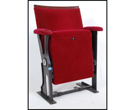 A vintage retro 20th century cinema seat having a cast metal frame with drop down seat. The seat pad and back rest having a p