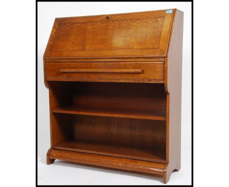 A vintage mid 20th century oak bureau. Having a fully appointed interior behind the fall front above a full length drawer wit