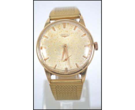 An 18ct gold vintage gentlemans Longines wristwatch having a baton numeral face with faceted hands and subsiduary dial. Set t