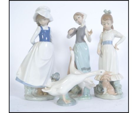 A collection of porcelain Lladro and Nao figurines to include a Lladro duck and 3 Nao figures to include 2 girls with dogs, o