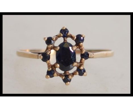 A 9ct gold and sapphire ladies ring, the central cabachon sapphire with surround sapphires, all claw mounted. The shank Londo