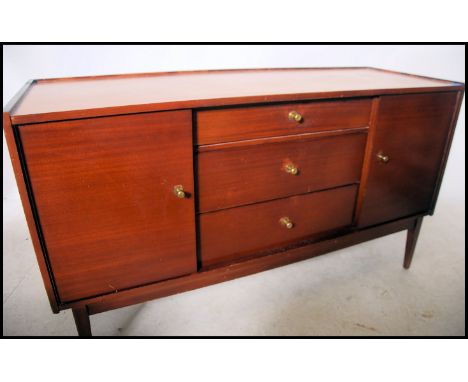A vintage / retro mid 20th century teak wood sideboard having a central bank of three drawers flanked by shelved cupboards ra