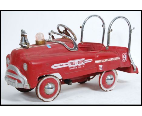 A vintage retro style child's tin plate peddle car in the form of a Fire Engine. Fire Depot decals to the side with bell and 