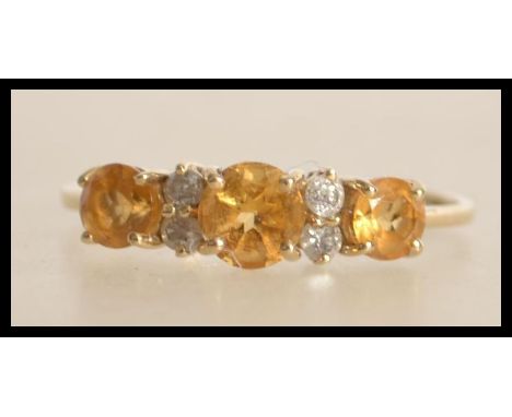 A 9ct gold ring set with white and yellow stones. Marked 9ct &nbsp;375 tests 9ct gold. &nbsp;Size R.