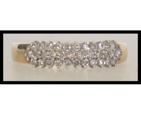 A 9ct gold and diamond ladies ring having rows of cluster diamonds approx 30-40pnts total . The shank bearing London hallmark