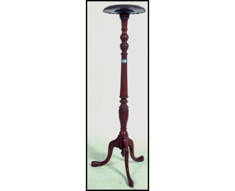 A 19th century mahogany torchere with reeded support raised on tripod feet.&nbsp;