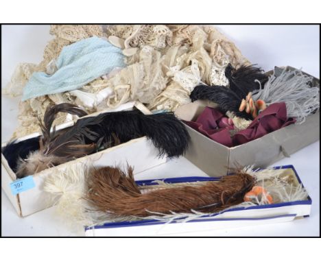 A collection of vintage late 19th and early 20th century lace together with a collection of vintage costume feathers to inclu
