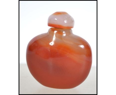 A 20th century Chinese jade snuff bottle of roundel form complete with stopper. Measures 5cm high.