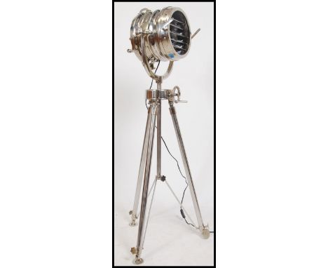 A stunning 20th century polished steel studio light raised on a matching tripod base. The superb theatre lamp with blinker mo